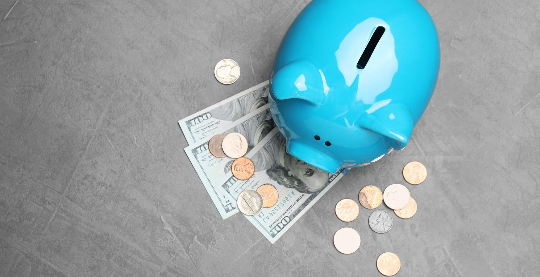 Blue piggy bank with money outside of it