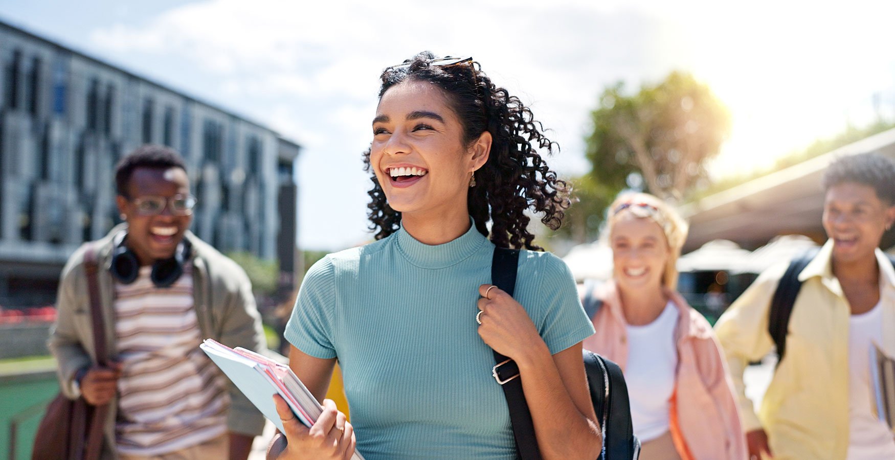Group of college students. Focus is on main girl holding books.