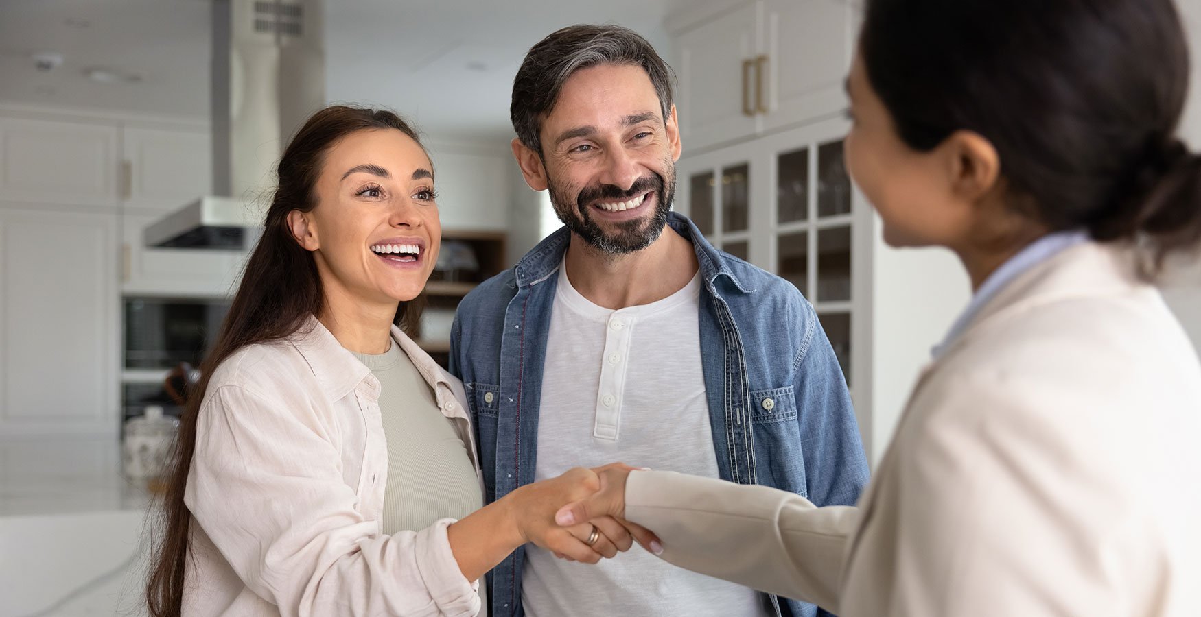 Man and woman meeting with another woman. Women are shaking hands.