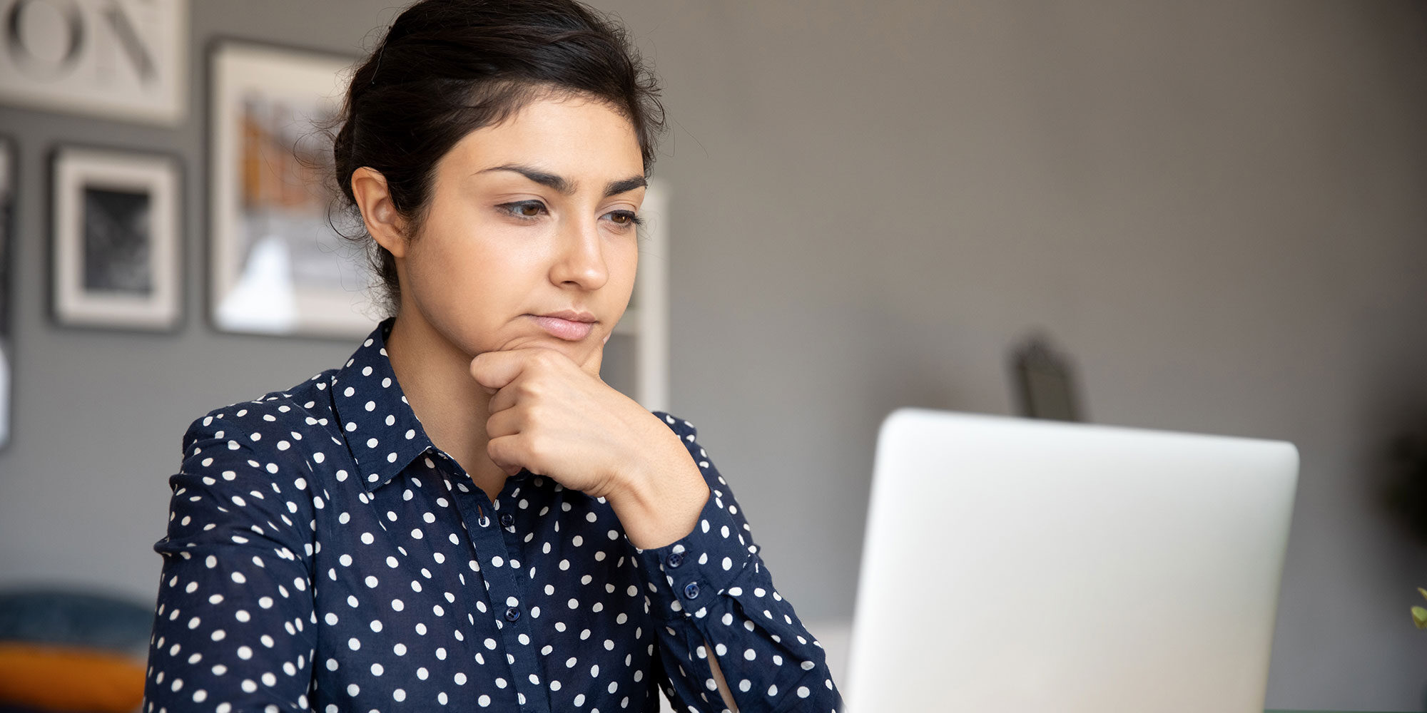 Girl with a thinking look on her face on her laptop. 