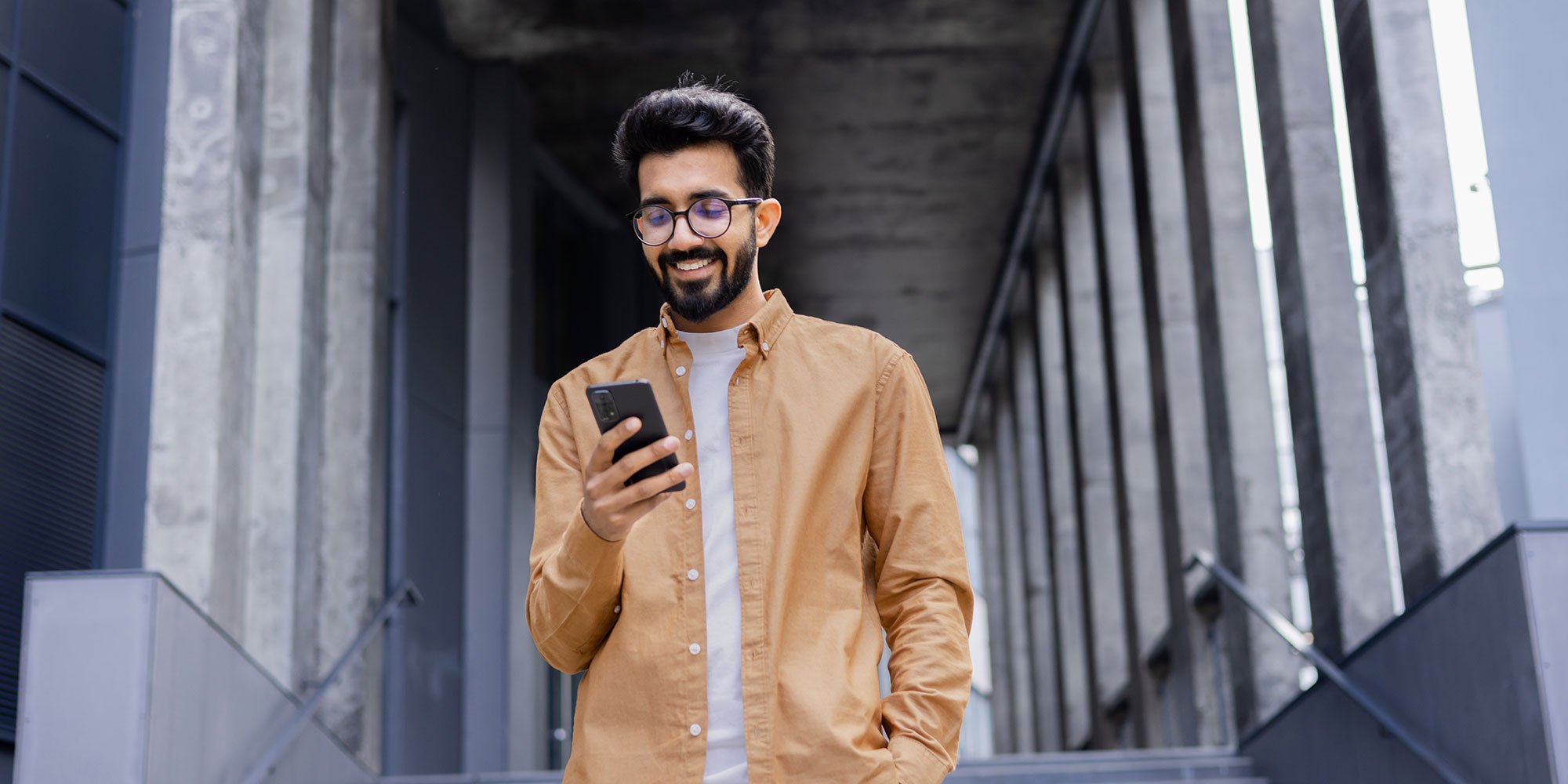 Man smiling down at his phone. 